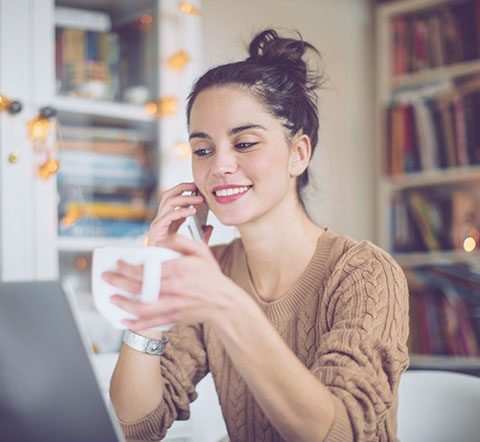 woman drinking from mug in her office